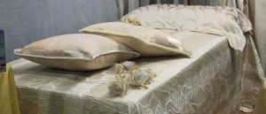 A bed with gold linens on top